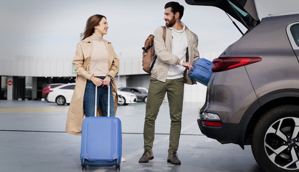Couple loading luggage into a car